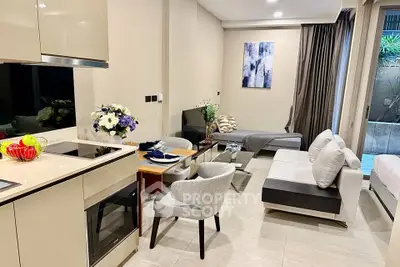 Modern living room with sleek kitchen and stylish decor in a contemporary apartment.