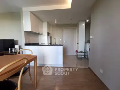 Modern open-plan kitchen and dining area with sleek design and wooden flooring