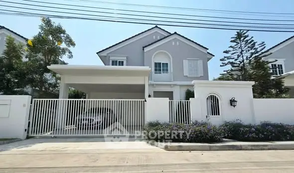 Elegant two-story house with a spacious driveway and lush garden, perfect for family living.