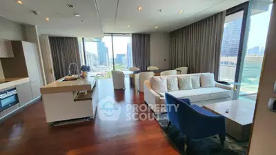 Luxurious open-plan living room with city view, modern kitchen, and elegant furnishings in high-rise apartment.
