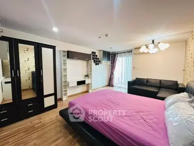 Spacious bedroom with modern furnishings and natural light in a stylish apartment.