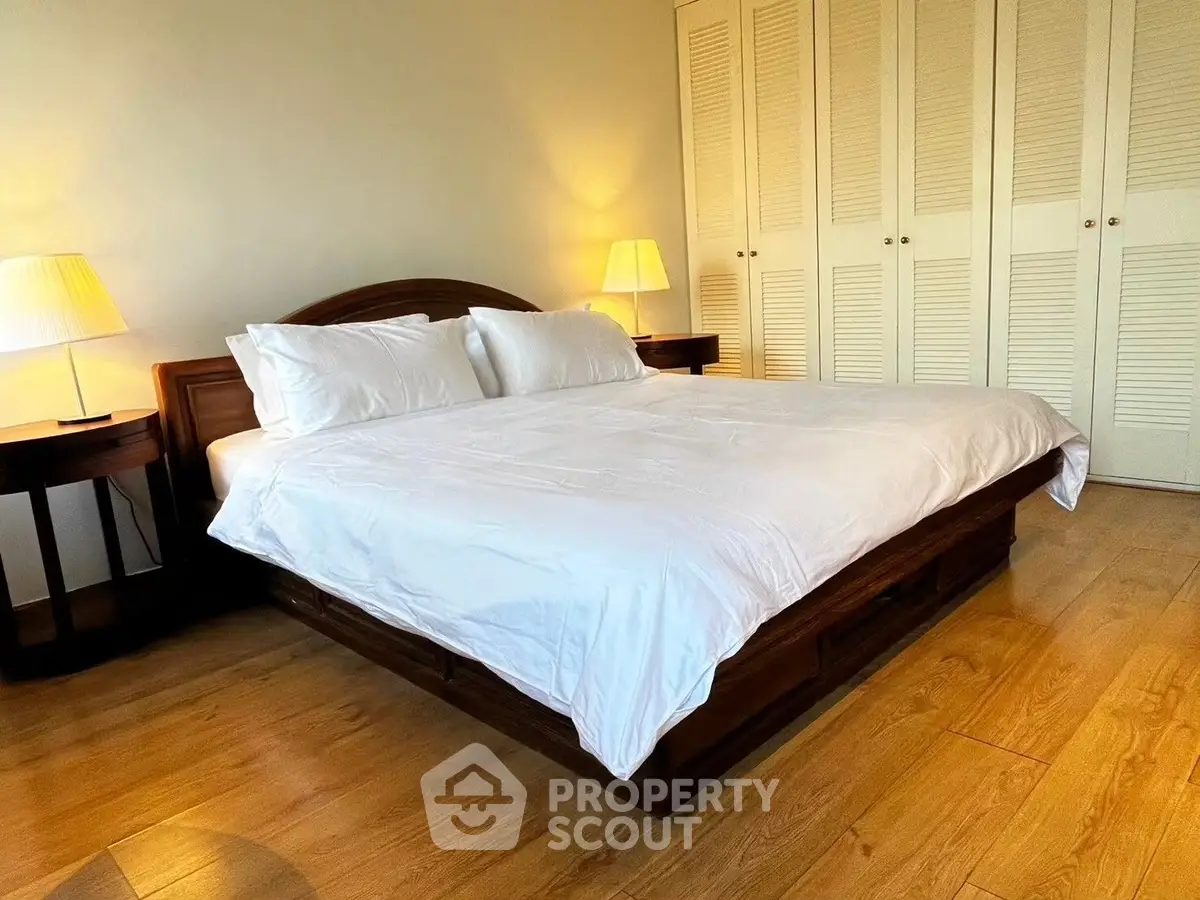 Spacious bedroom with elegant wooden flooring and cozy lighting