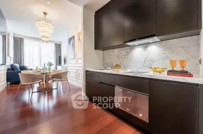 Luxurious open-layout kitchen and dining area with elegant chandelier and modern decor.