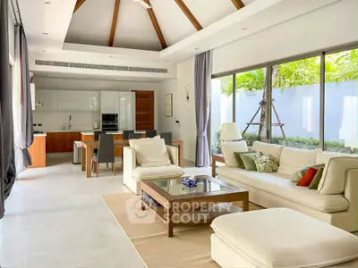 Spacious open-plan living room with modern kitchen and garden view, featuring elegant decor and natural light.