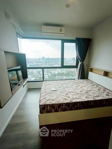 Modern bedroom with large window offering stunning city view, featuring a cozy bed and sleek TV setup.