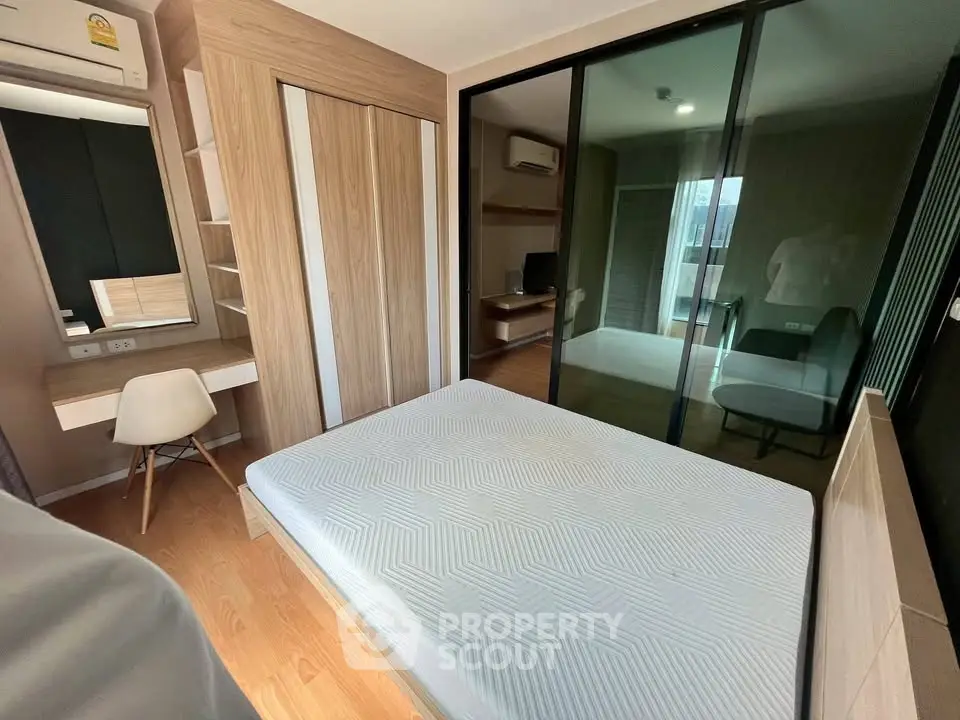 Modern bedroom with sleek design, built-in wardrobe, and workspace in a cozy apartment.