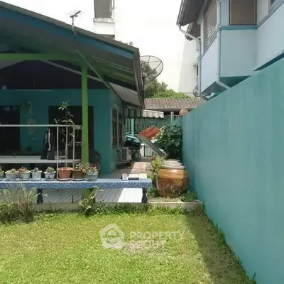 Charming garden view with lush greenery and cozy patio area in residential property.