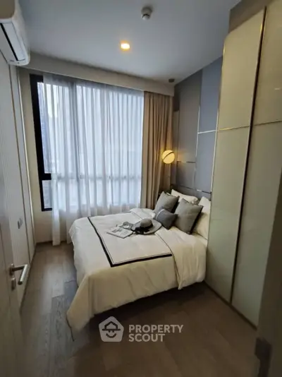 Modern cozy bedroom with stylish decor and large window for natural light