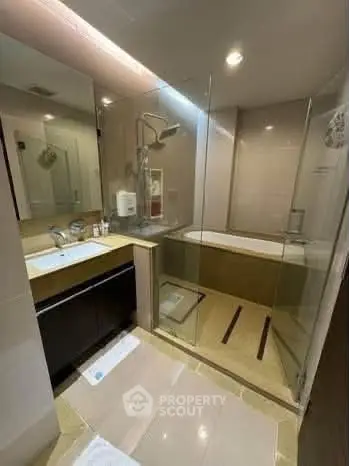 Modern bathroom with glass shower and bathtub in luxury apartment