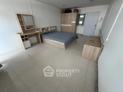 Spacious bedroom with modern wooden furniture and sleek tile flooring