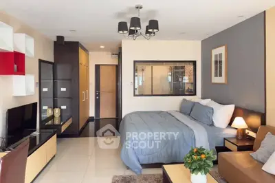 Modern studio apartment with stylish decor and cozy ambiance, featuring a comfortable bed and elegant lighting.