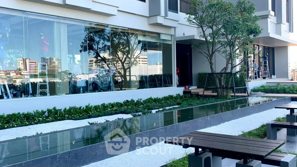 Modern building exterior with landscaped garden and reflective glass windows