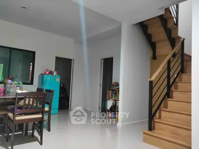 Spacious living area with gleaming tiled floors and an elegant wooden staircase leading to the upper level, perfect for family gatherings.