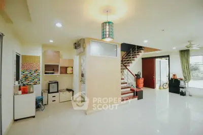 Spacious open-plan living area with modern decor and staircase, ideal for family gatherings.