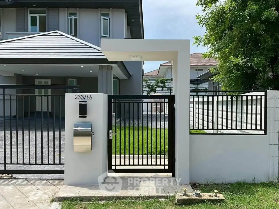 Modern house exterior with sleek gate and lush green lawn