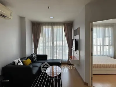 Modern living room with sleek furniture and large windows in a stylish apartment.