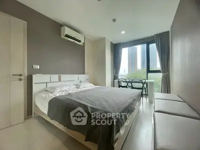 Modern bedroom with large window and city view, featuring a comfortable bed and stylish decor.