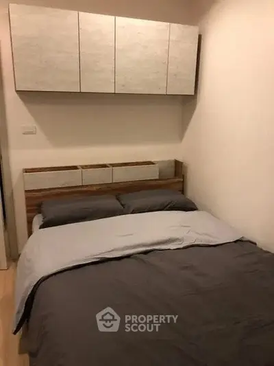 Cozy bedroom with modern cabinetry and comfortable bedding in a compact space.