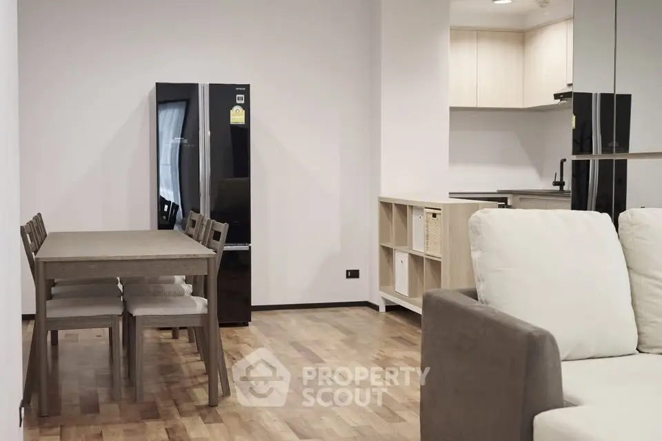 Modern open-plan living room with dining area and sleek kitchen in a stylish apartment.