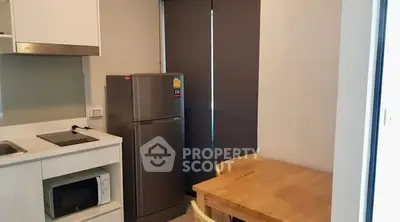 Modern kitchen with sleek appliances and cozy dining area in a compact space.