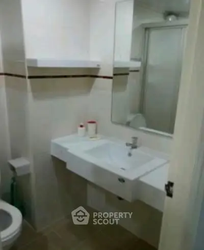 Compact bathroom with modern sink and mirror, featuring a sleek design and neutral color palette.