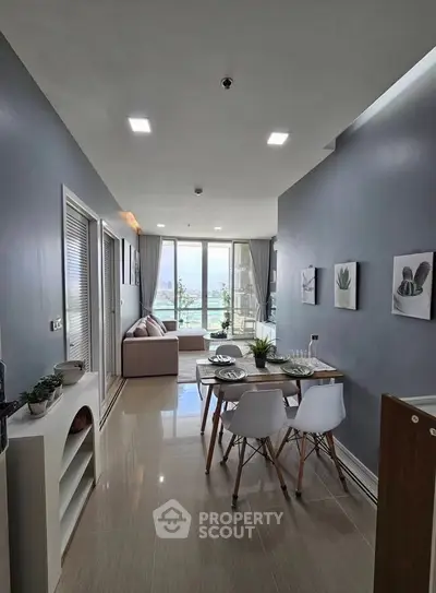 Modern living room with dining area and city view, featuring sleek furniture and decor.