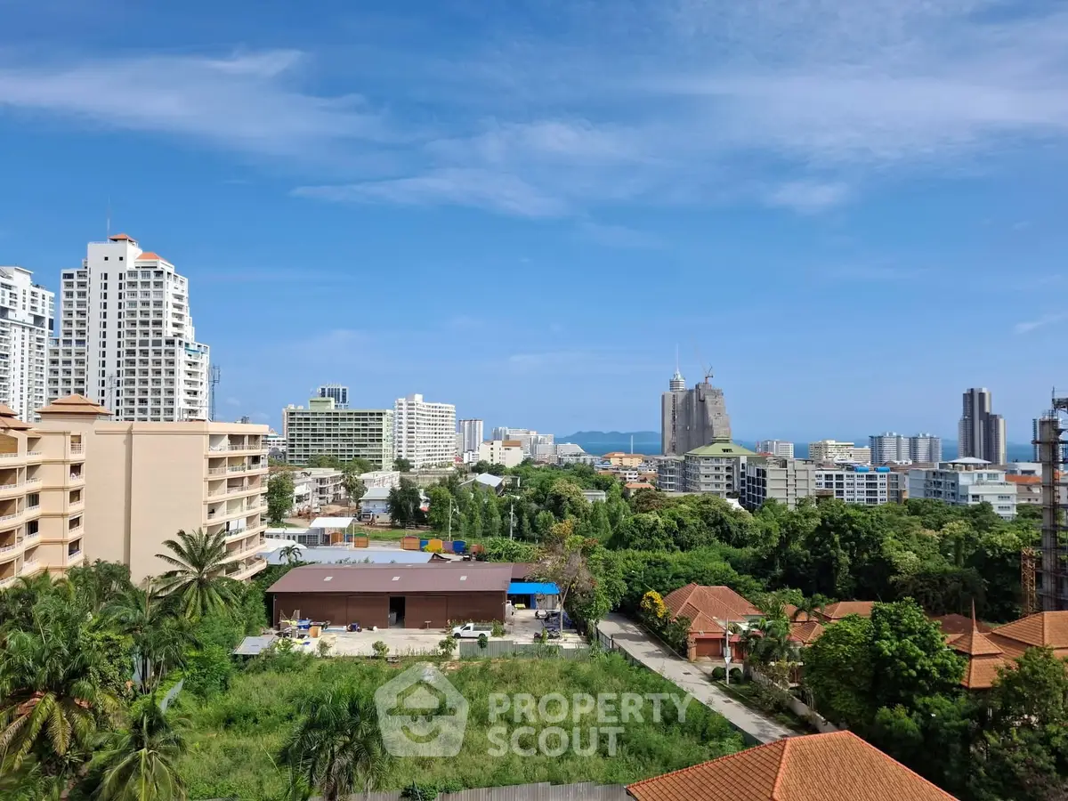 Stunning cityscape view with lush greenery and modern high-rise buildings under a clear blue sky.
