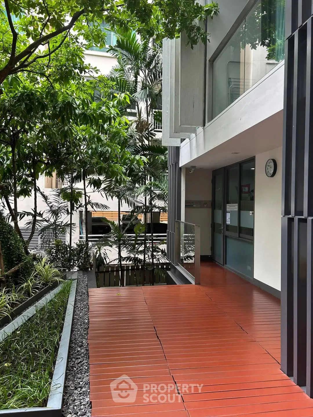 Modern building entrance with lush greenery and sleek design