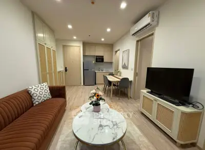 Modern living room with stylish furniture and open kitchen layout in a cozy apartment.