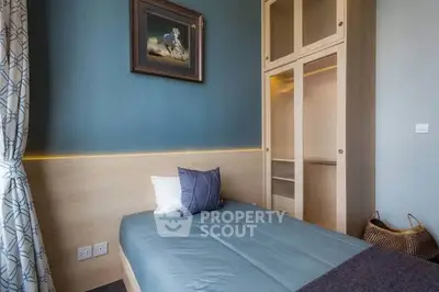 Cozy bedroom with modern decor and built-in wardrobe, perfect for relaxation.