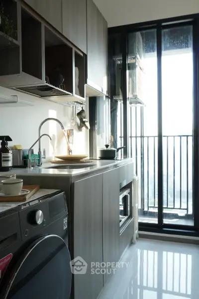 Modern kitchen with sleek cabinetry and balcony view