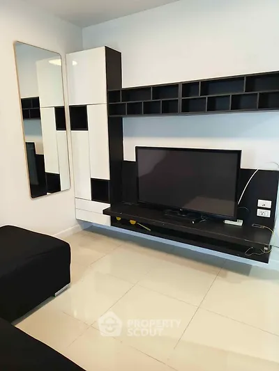 Modern living room with sleek black and white entertainment unit and wall-mounted TV.