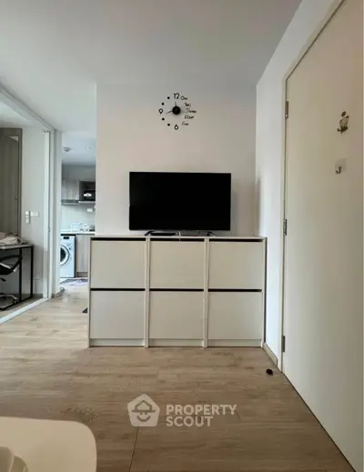 Modern living room with sleek TV setup and open kitchen view