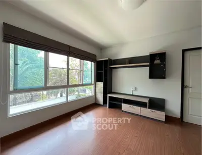 Spacious room with large windows and modern shelving unit, perfect for versatile living space.