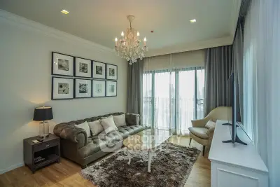 Elegant living room with chandelier, plush sofa, and large windows for natural light.