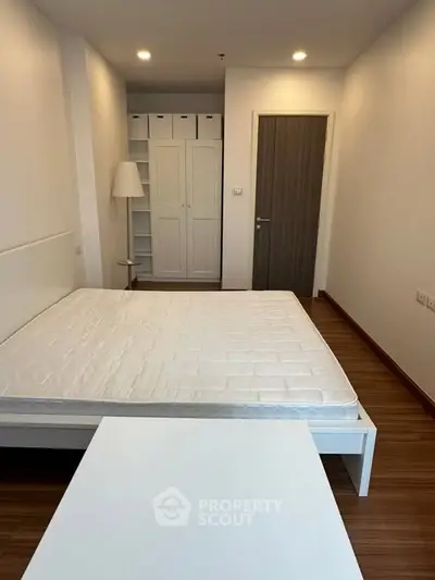 Spacious bedroom with modern design and ample storage in a stylish apartment.