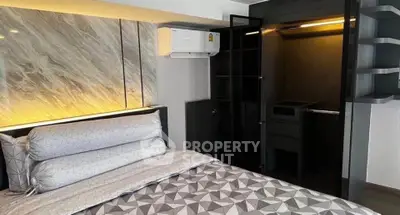 Modern bedroom with stylish decor and built-in closet, featuring elegant lighting and contemporary design.