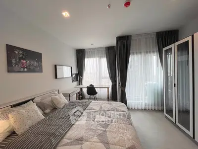 Modern bedroom with stylish decor and large windows offering natural light