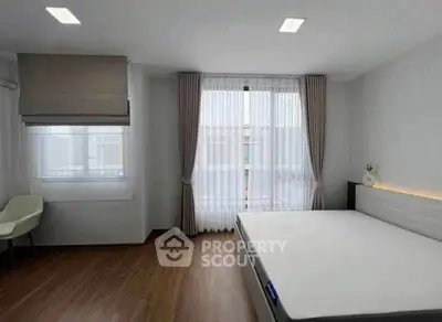 Spacious minimalist bedroom with large windows and modern design.