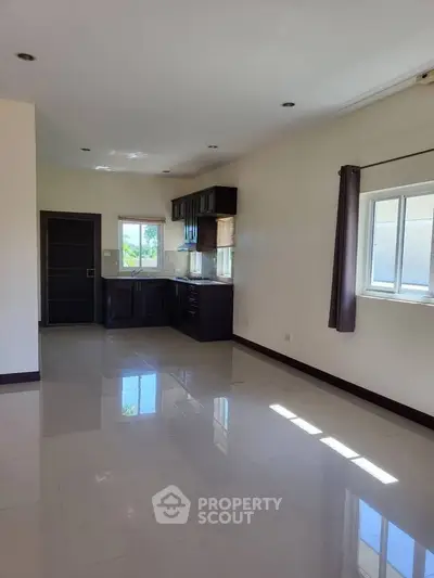 Spacious open-plan living area with modern kitchen and large windows