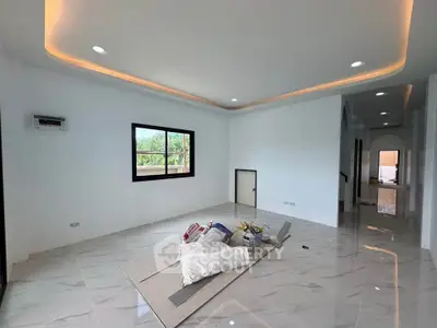 Spacious modern living room with elegant lighting and large window view.