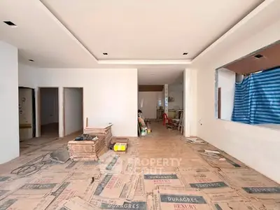 Spacious under-construction living room with modern design and ample natural light.