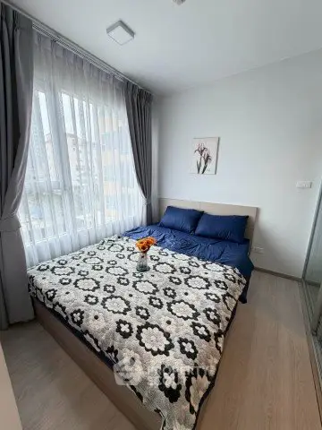 Cozy bedroom with large window and stylish decor in modern apartment.