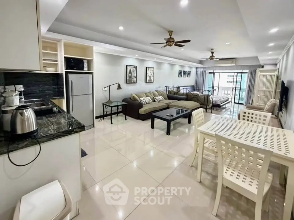Spacious open-plan living room with modern kitchen and balcony view