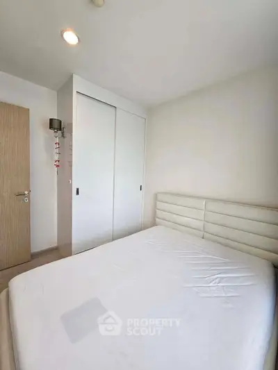 Cozy minimalist bedroom with white sliding closet and padded headboard