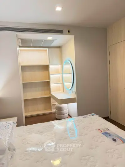 Modern bedroom with stylish vanity and built-in shelves, featuring elegant lighting and cozy atmosphere.