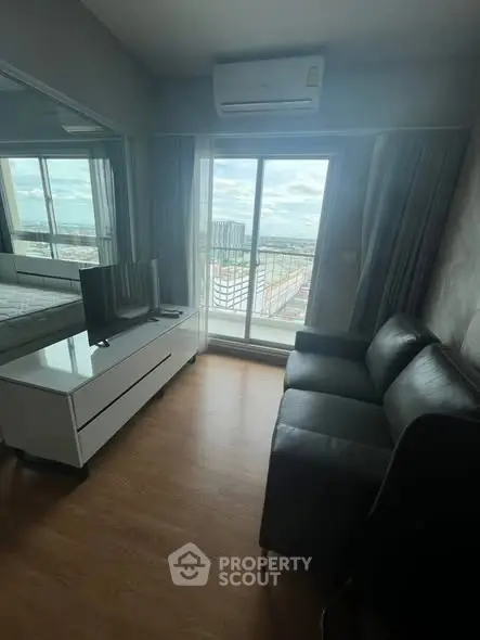 Modern living room with sleek furniture and stunning city view from balcony.