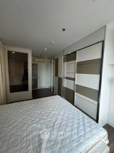 Modern bedroom with stylish wardrobe and cozy ambiance in a contemporary apartment.