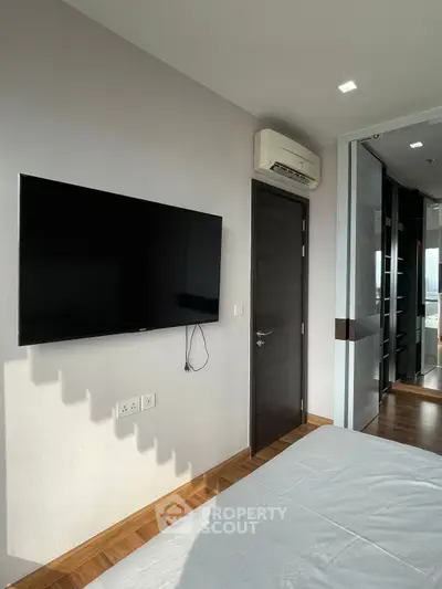Modern bedroom with wall-mounted TV and sleek air conditioning unit