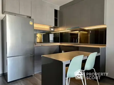 Modern kitchen with sleek cabinetry and stainless steel fridge in stylish apartment